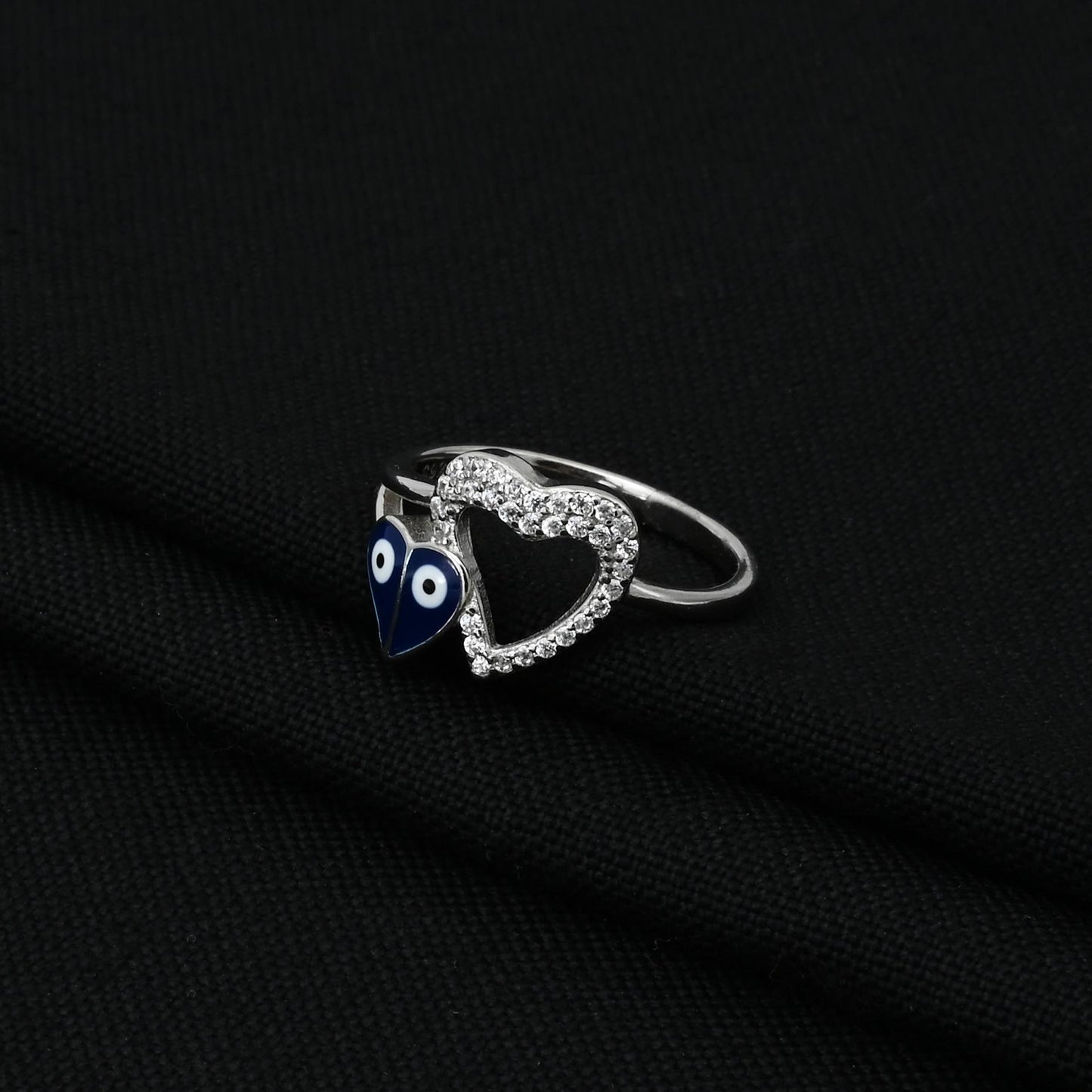 Trendy silver ring showcasing a unique heart shape with evil eye symbols, perfect for adding a touch of charm and protection