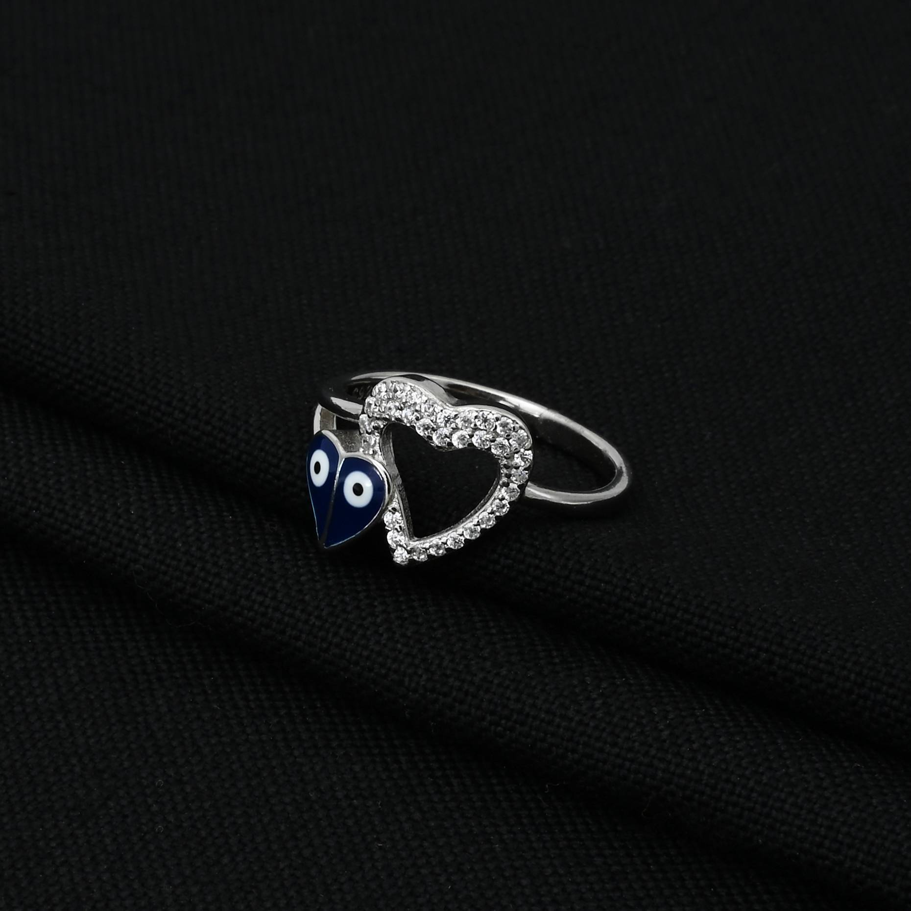 Trendy silver ring showcasing a unique heart shape with evil eye symbols, perfect for adding a touch of charm and protection