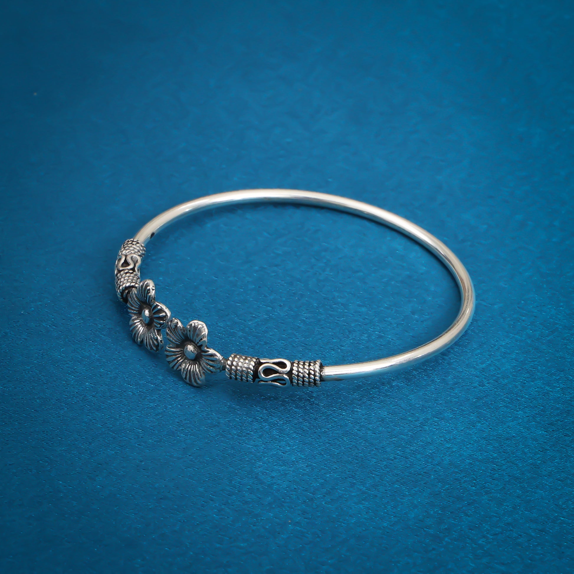 Stylish oxidized silver bangle adorned with detailed floral patterns