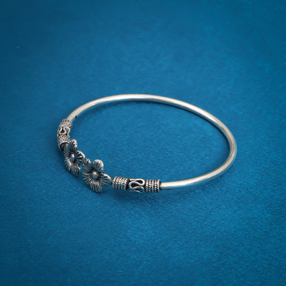 Stylish oxidized silver bangle adorned with detailed floral patterns