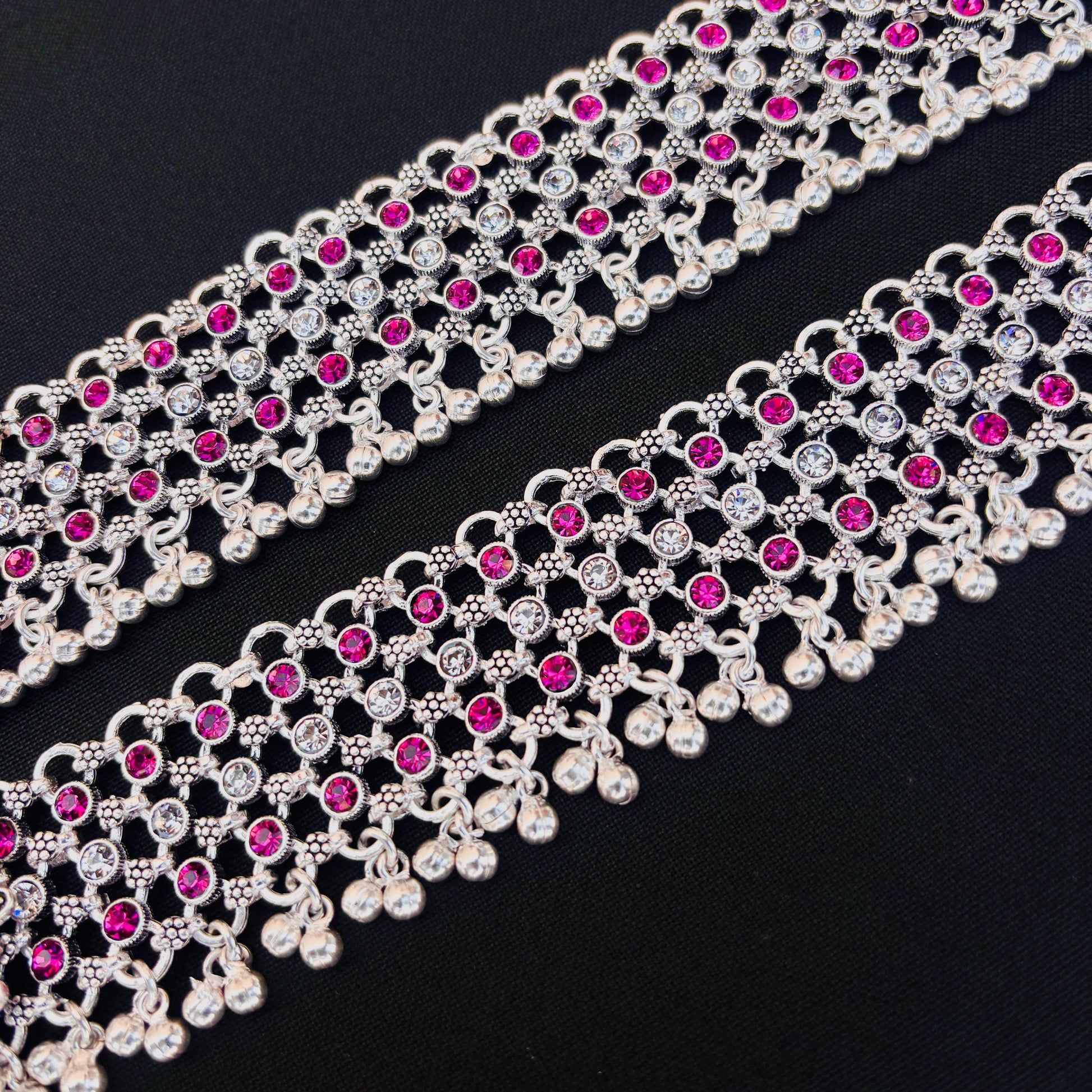 Traditional silver payal featuring purple and white stones in flower design.