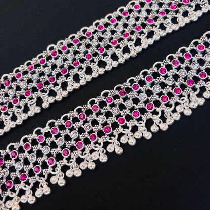 Traditional silver payal featuring purple and white stones in flower design.