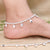 Silver anklet featuring delicate teardrop charm accents.