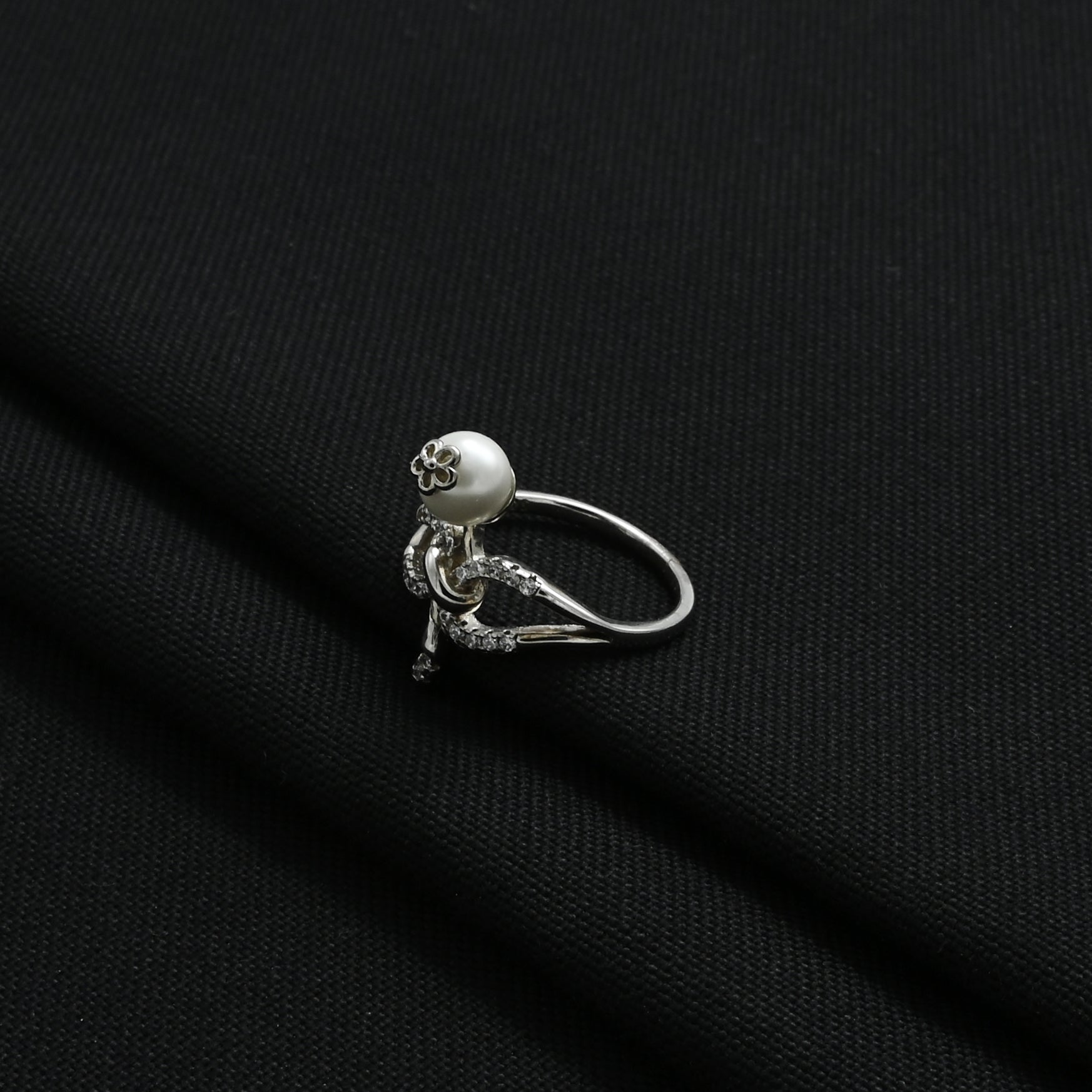 Stylish silver ring showcasing a pearl in the center of a flower design.