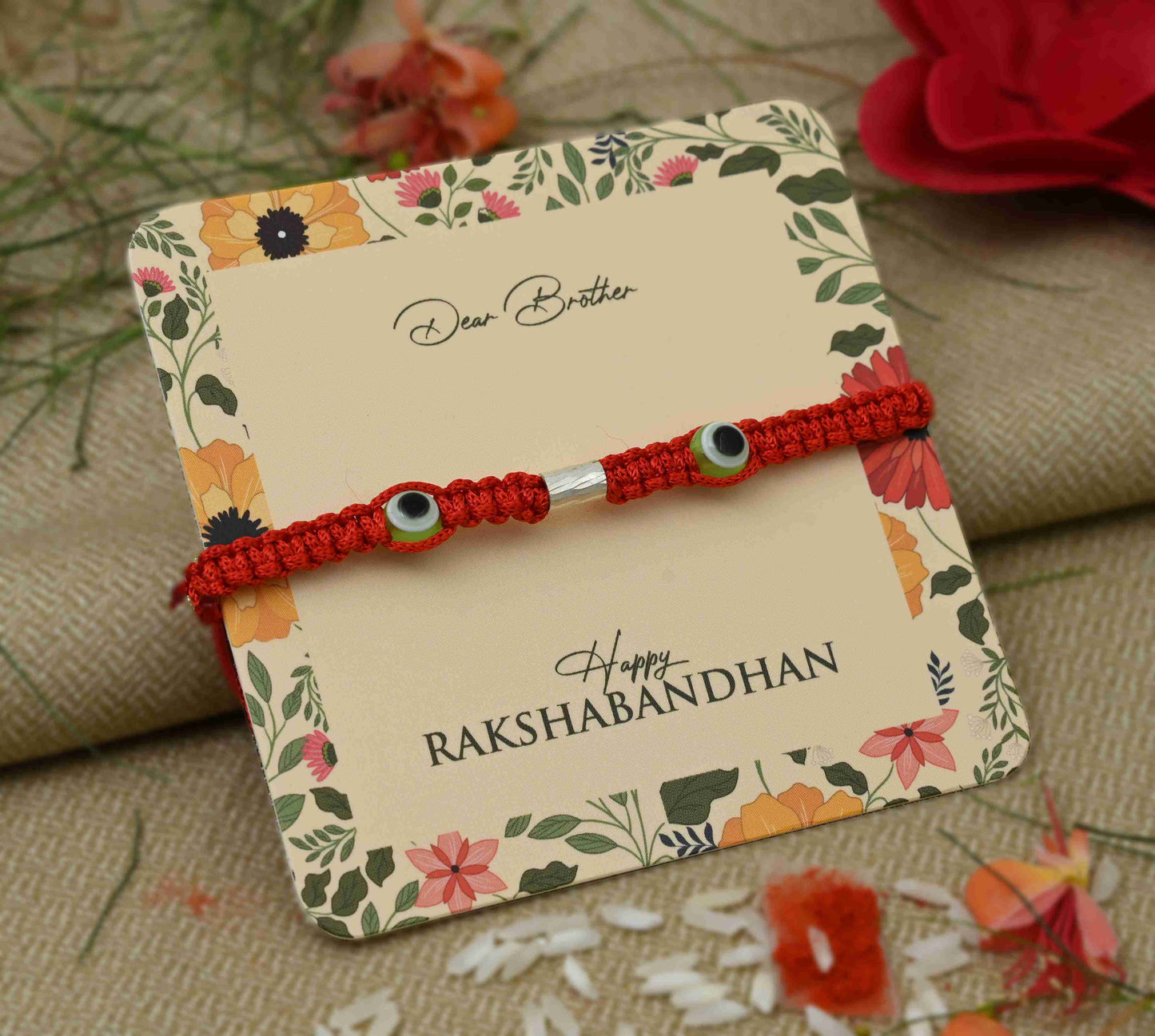 Silver Rakhi featuring two green evil eye symbols, perfect for boys