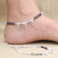 Sterling silver anklet featuring a shell design accented with black beads