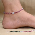 Silver anklet featuring a combination of ruby stones and an evil eye charm