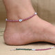 Silver anklet featuring a combination of ruby stones and an evil eye charm