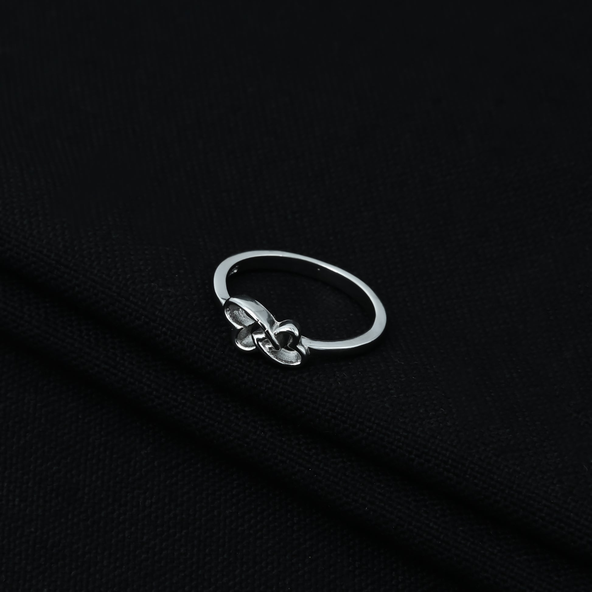 Stylish sterling silver ring featuring interlocked hearts, symbol of unity.