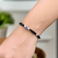 Sterling silver bracelet featuring a protective evil eye with black bead accents