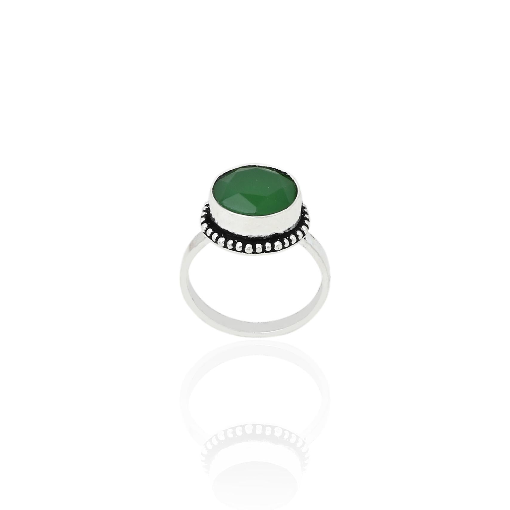 Close-up of a silver ring with a gorgeous green gemstone, perfect for adding a pop of color and sophistication.