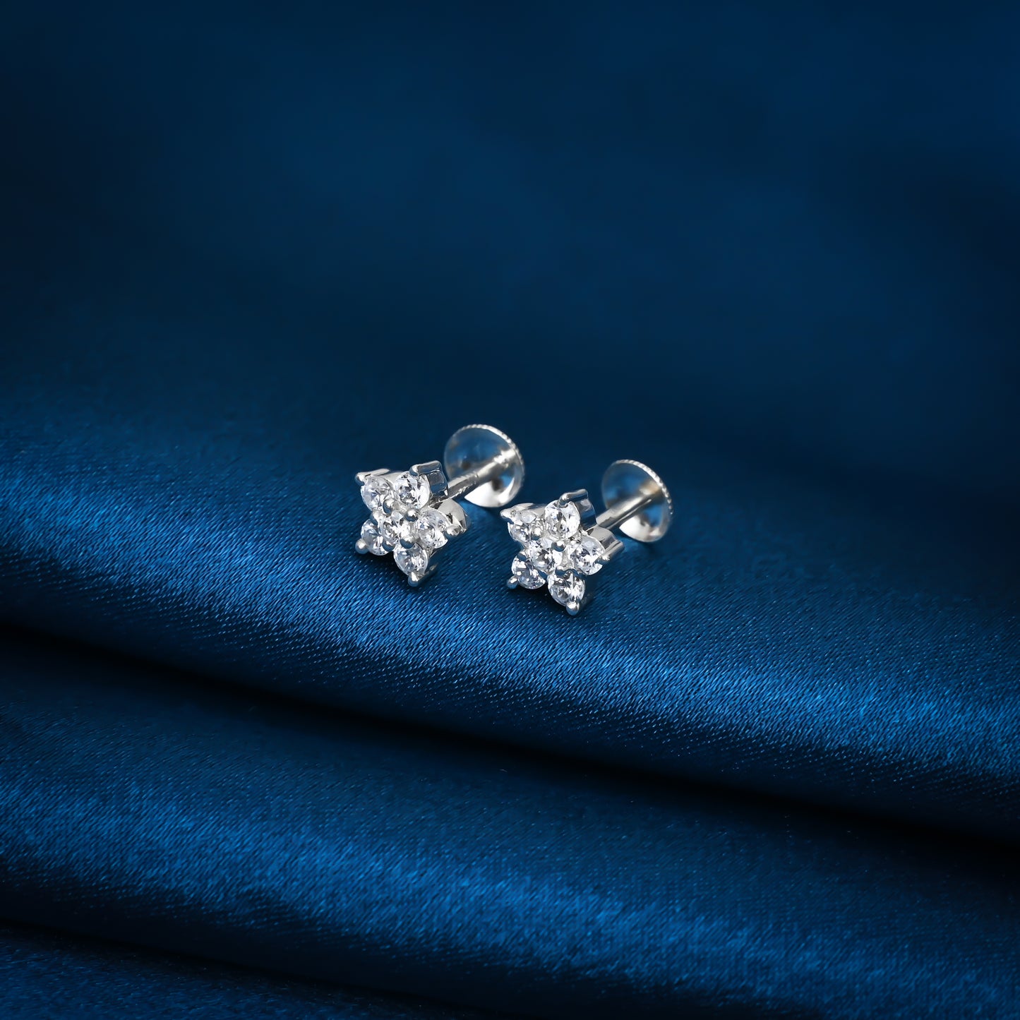 Timeless flower-shaped silver earrings adorned with white stones