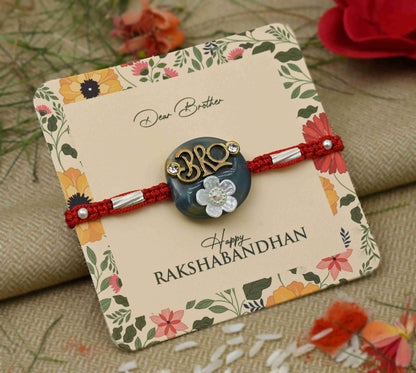 Silver center 'Bro' design on a blue background with a white flower, perfect Rakhi for boys.