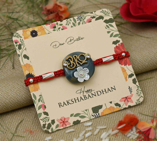Silver center 'Bro' design on a blue background with a white flower, perfect Rakhi for boys.