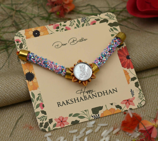Silver Baal Gopal centerpiece with pink and blue flat circular beads Rakhi for boys.