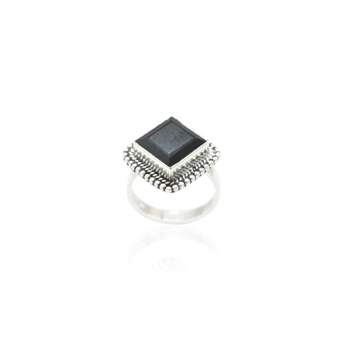 Close-up of a silver ring with black beads, combining sleek silver with a sophisticated beady pattern.