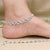 Graceful silver anklet with floral patterns and sparkling gemstones.