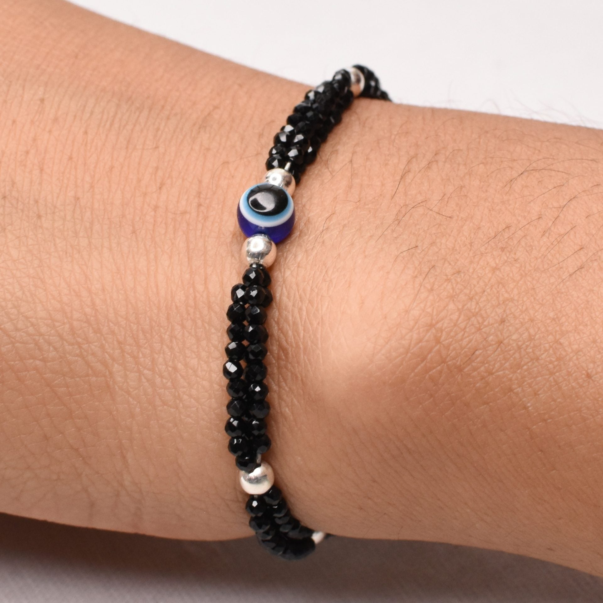 Sterling silver bracelet for girls featuring a blue evil eye charm with black beads