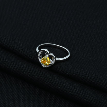 Silver ring adorned with a yellow heart-shaped gem.