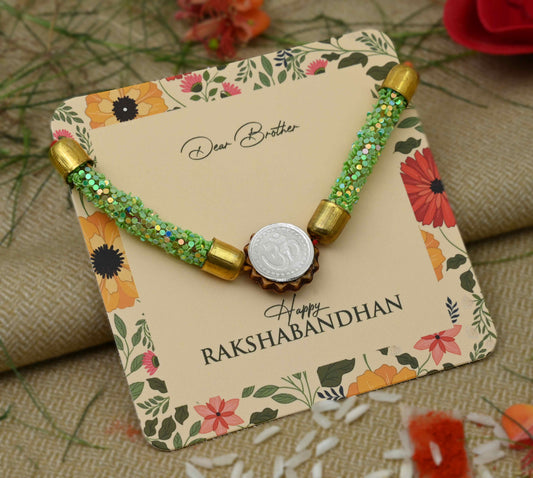 Silver center Om design with green flat circular plastic beads, perfect Rakhi for boys.