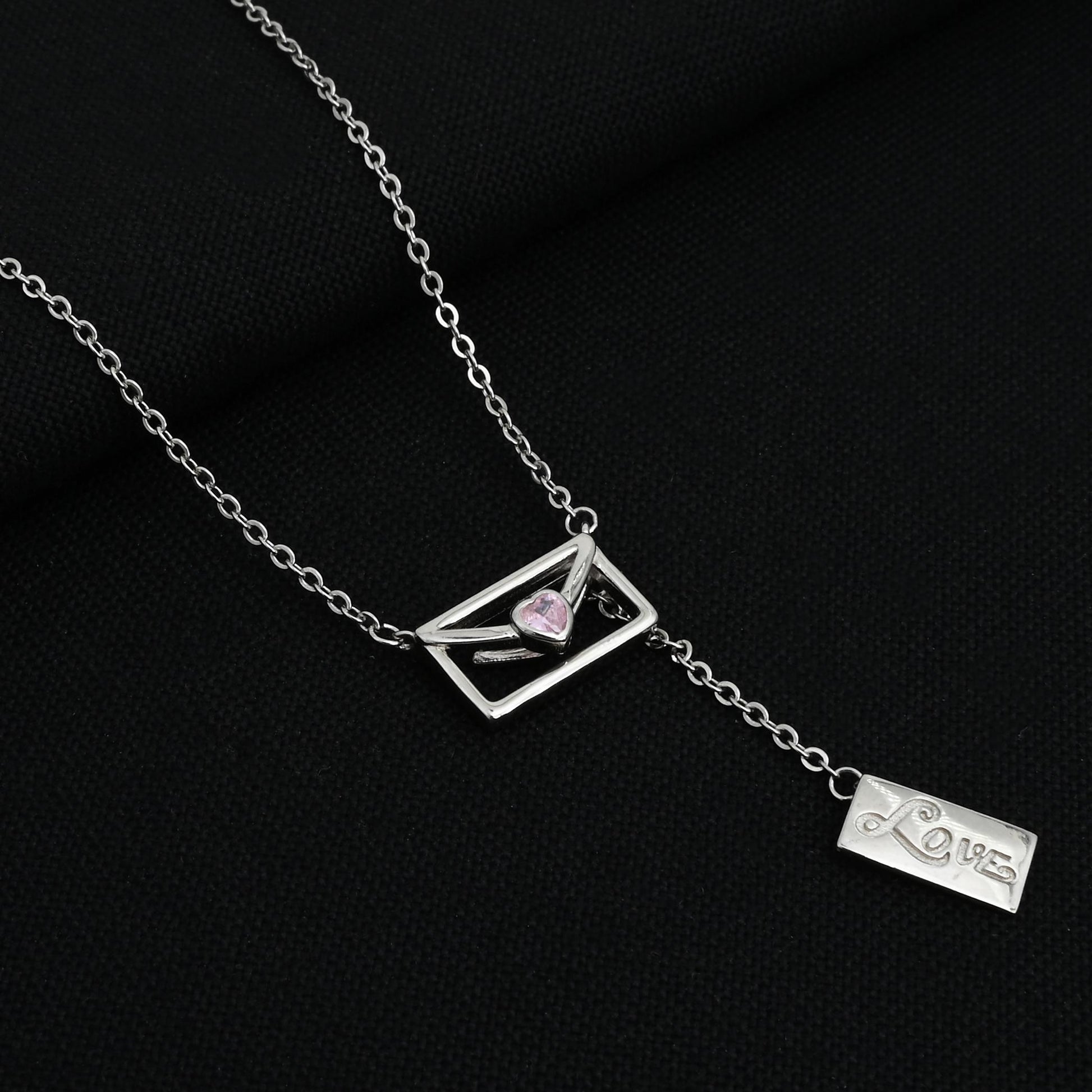 Close-up of a silver chain featuring a love message box pendant.