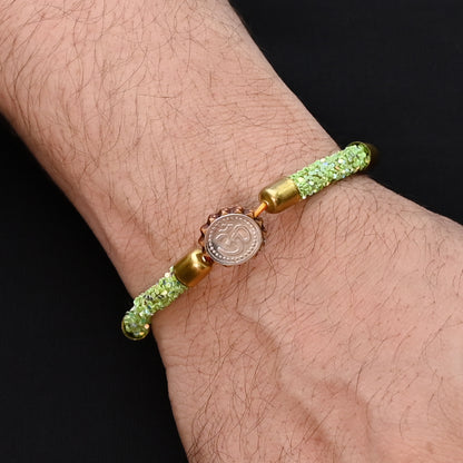 Elegant Rakhi with a silver Om symbol and green flat circular beads, ideal for boys.