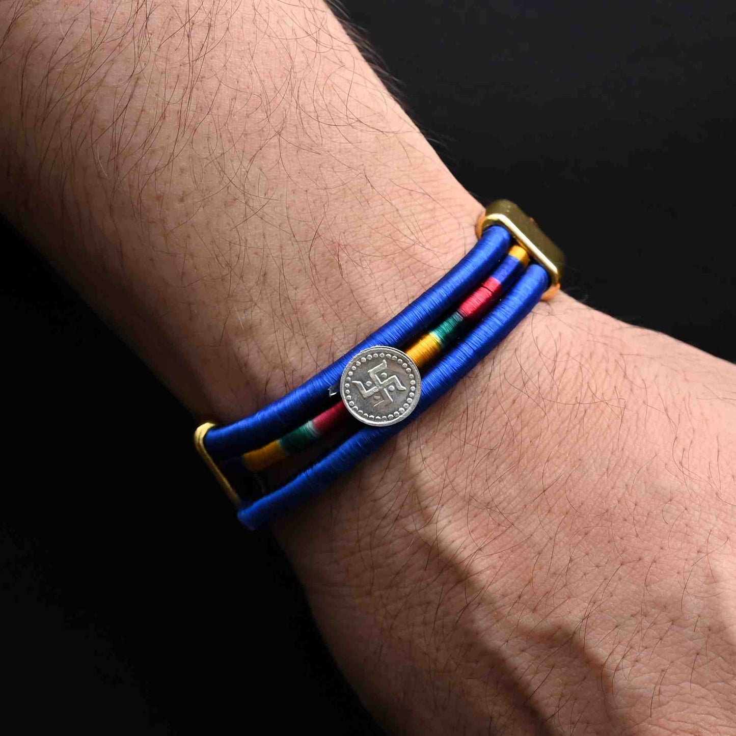 Elegant Rakhi with a silver Swashtika symbol and a bold blue ribbon, ideal for boys.
