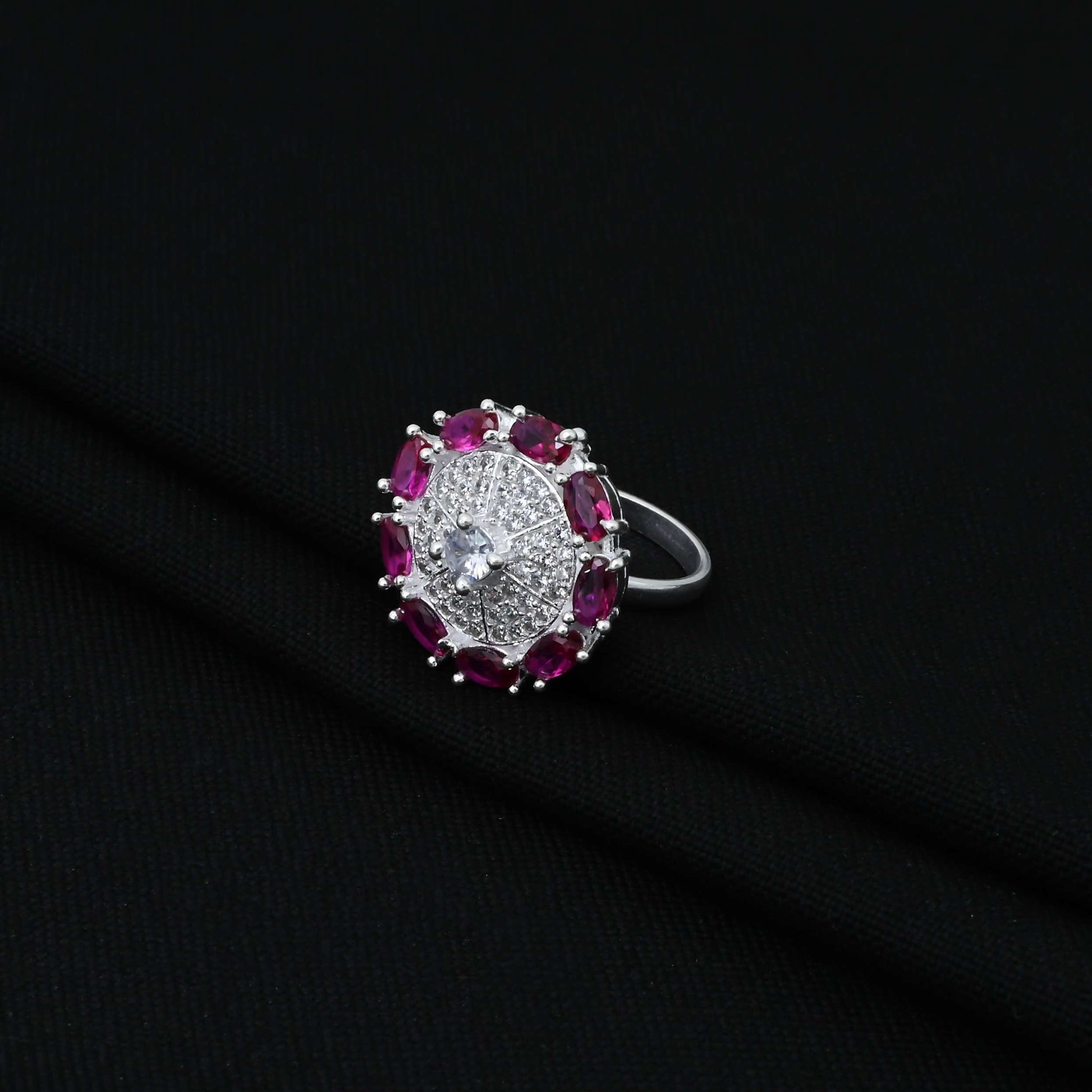 Stylish silver ring showcasing a round design with purple gems at the perimeter.