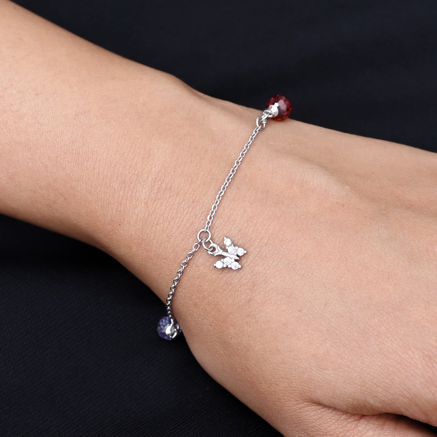 Elegant silver bracelet adorned with a butterfly and flower motif, perfect for a feminine and playful look