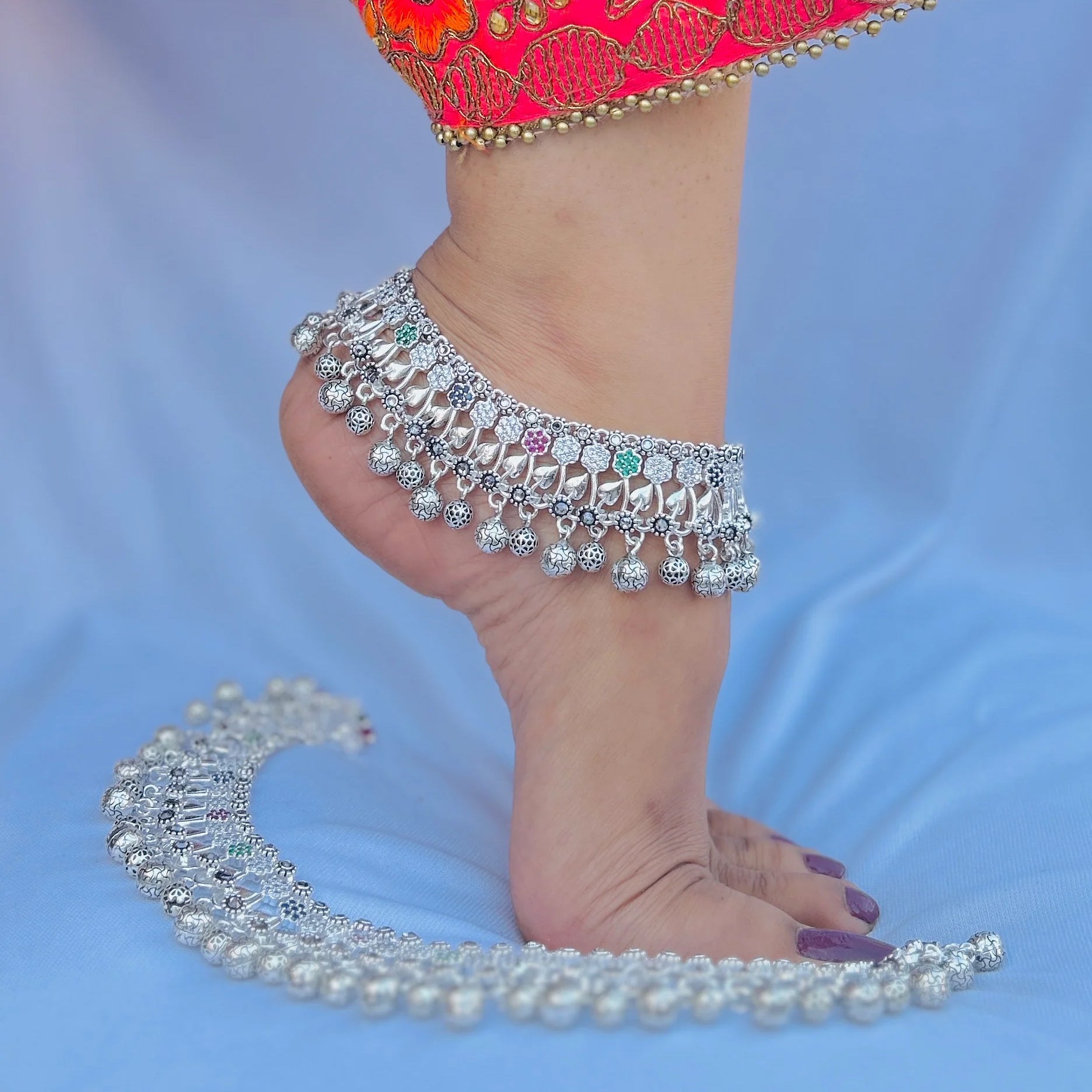 Silver payal featuring multicolored stone accents.