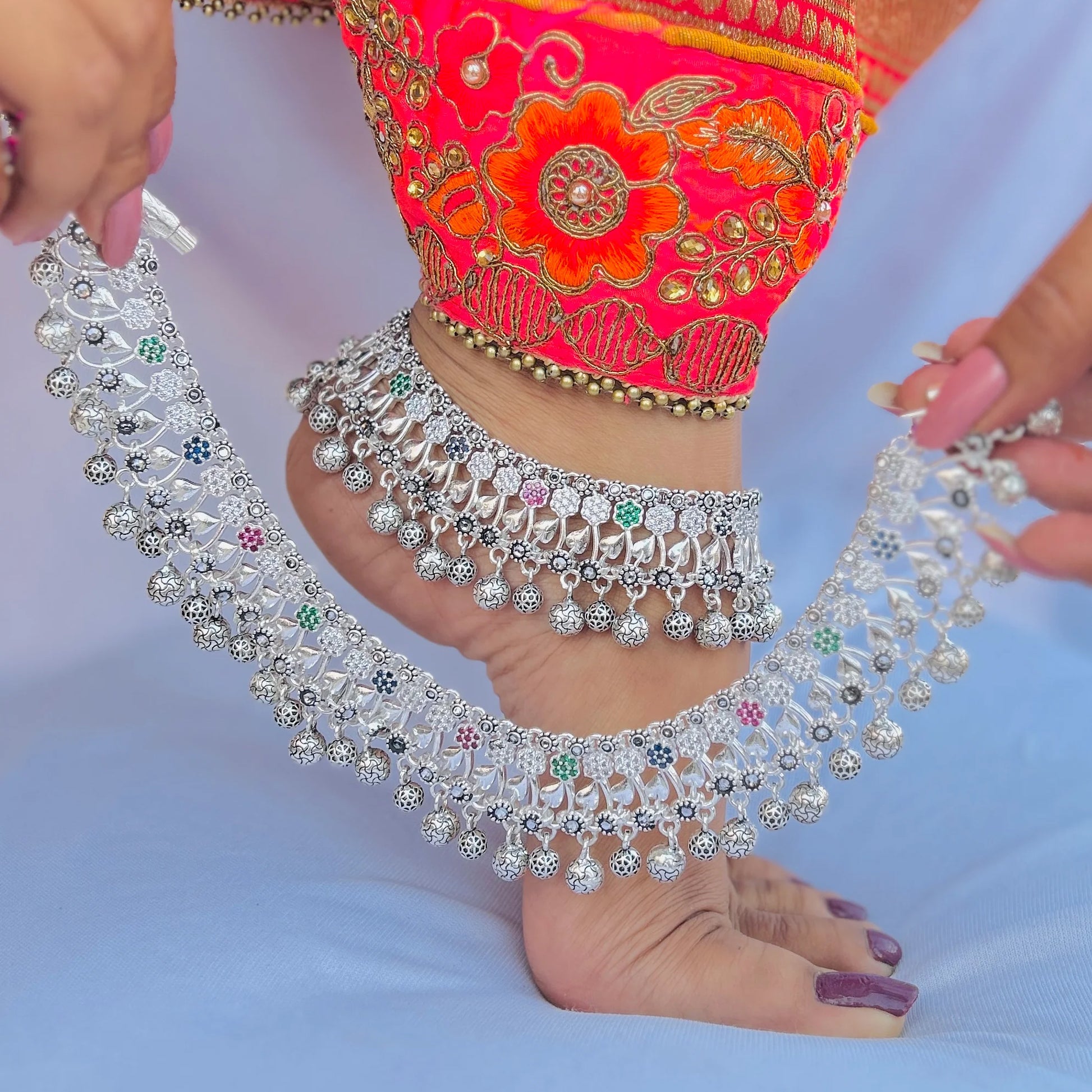 Ethnic silver payal with colorful stone details.