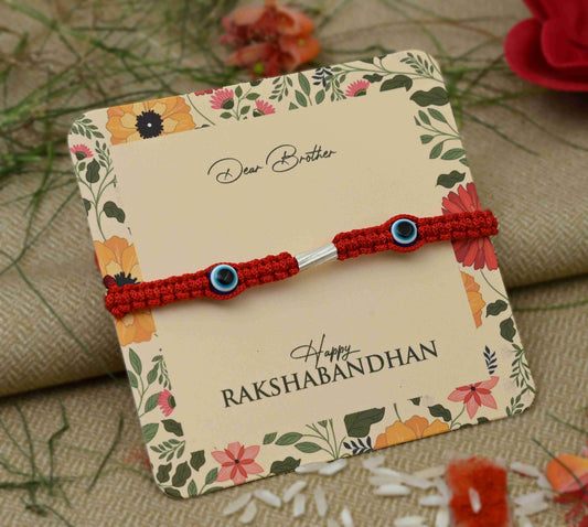 Silver Rakhi featuring two purple evil eye charms, perfect for boys.