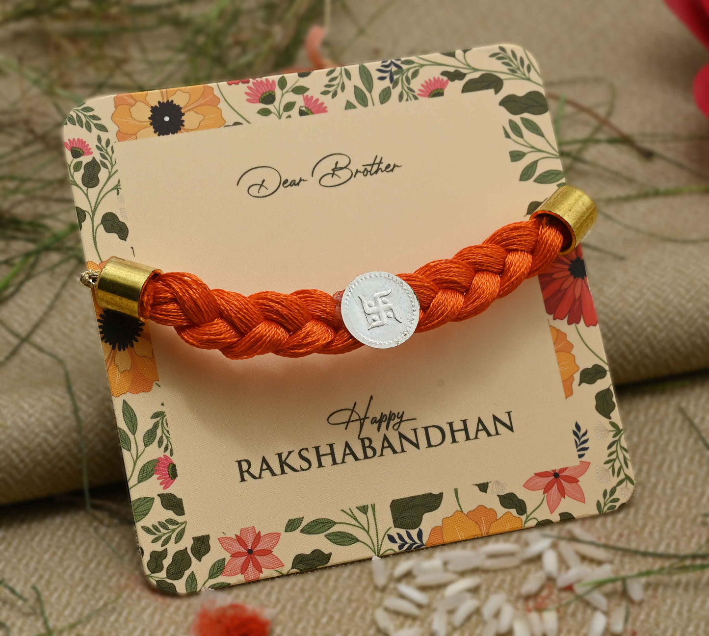 Silver center Swastika design with orange tangle Moli, perfect Rakhi for boys.