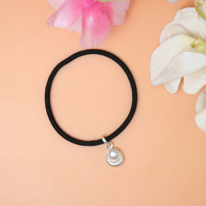A string bracelet featuring a delicate silver charm