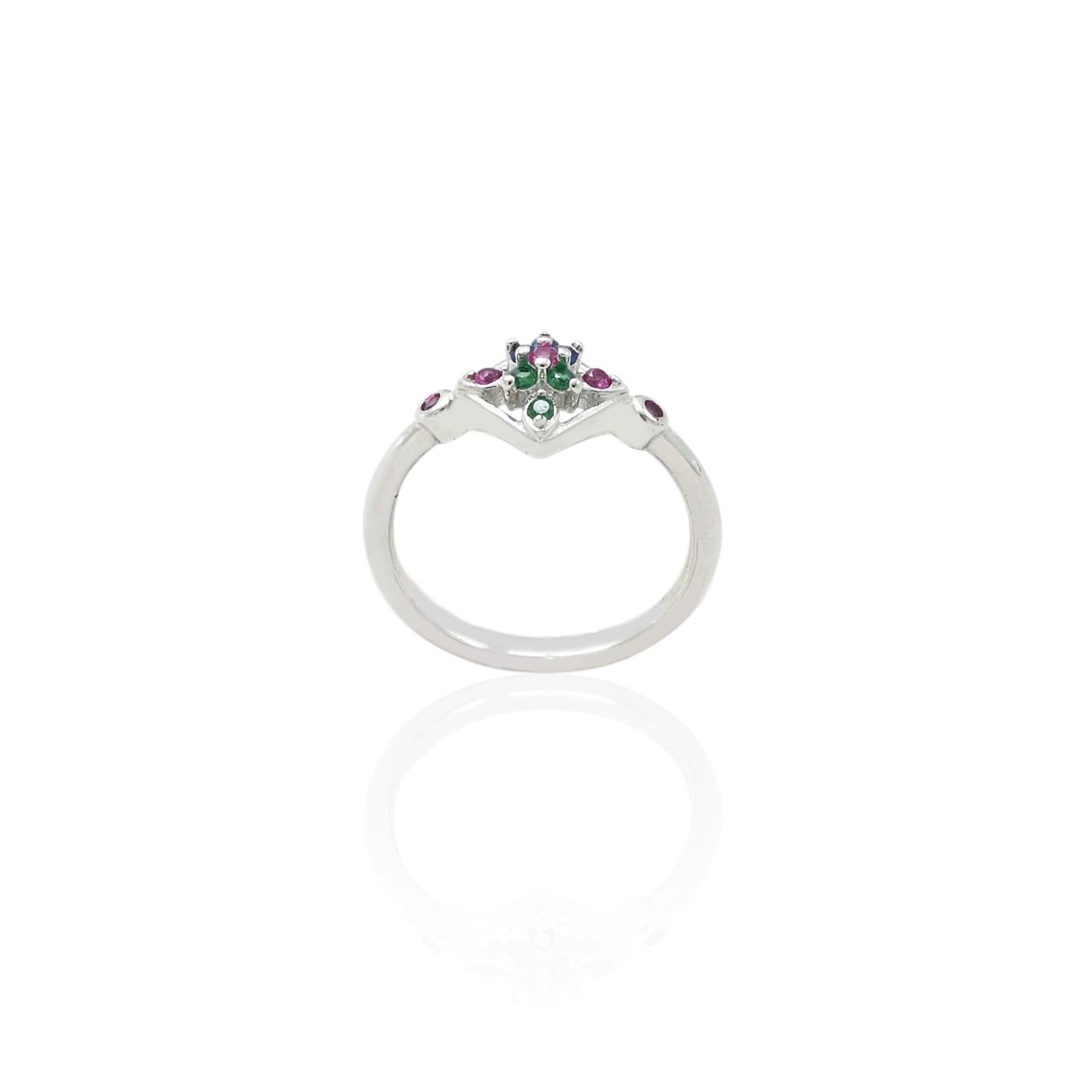 Close-up of a silver ring featuring green and pink gemstones, perfect for adding a pop of color to any outfit.