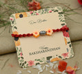 Sterling silver Rakhi featuring a vibrant orange flower design, perfect for boys.