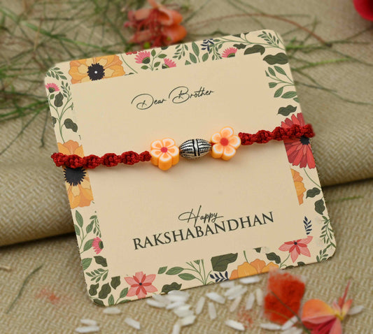 Sterling silver Rakhi featuring a vibrant orange flower design, perfect for boys.