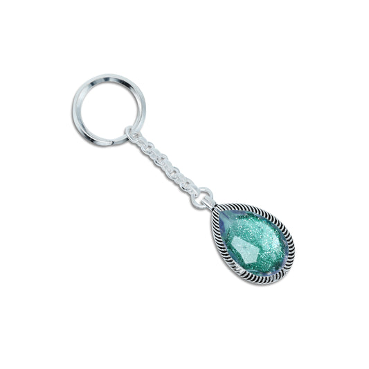 Elegant silver keychain featuring a teardrop design with a vibrant green gemstone