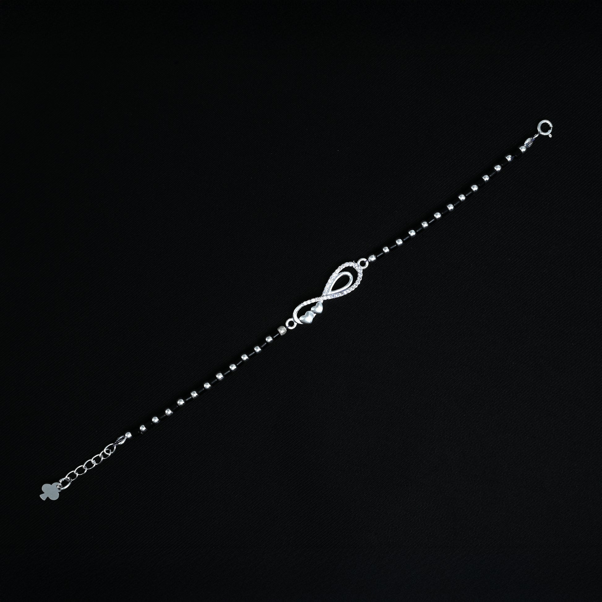 Silver bracelet featuring black beads and a timeless infinity symbol design