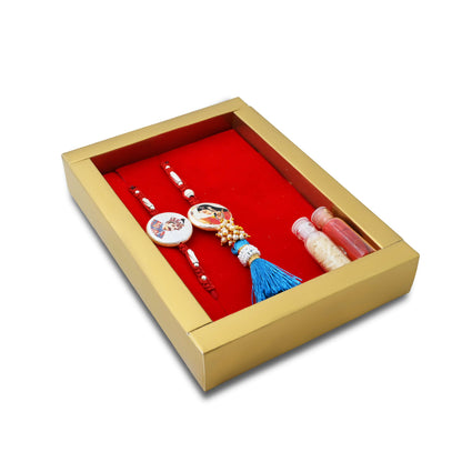 Silver Raja Rani Rakhi with a blue theme, complemented by kumkum and rice, perfect for boys.