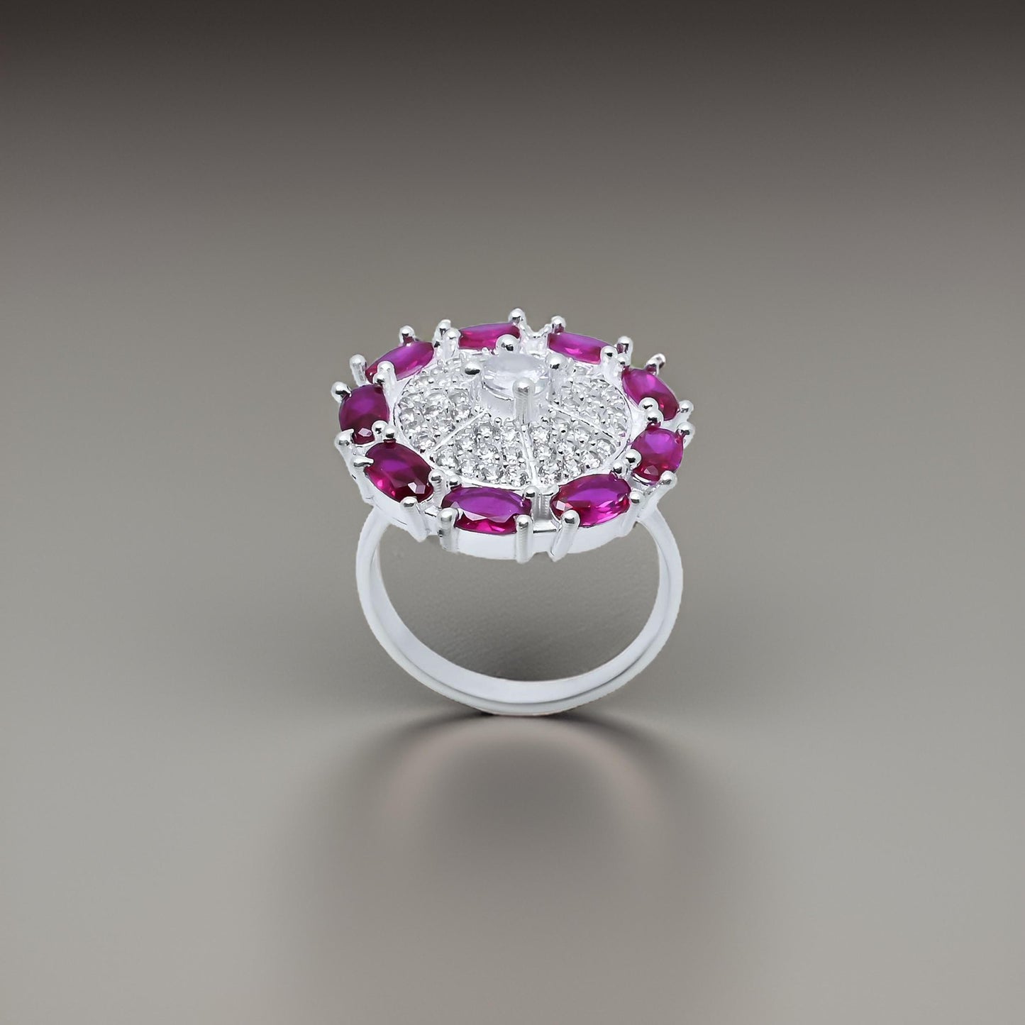 Elegant silver ring with a round shape, adorned with purple gem stones along the edge.