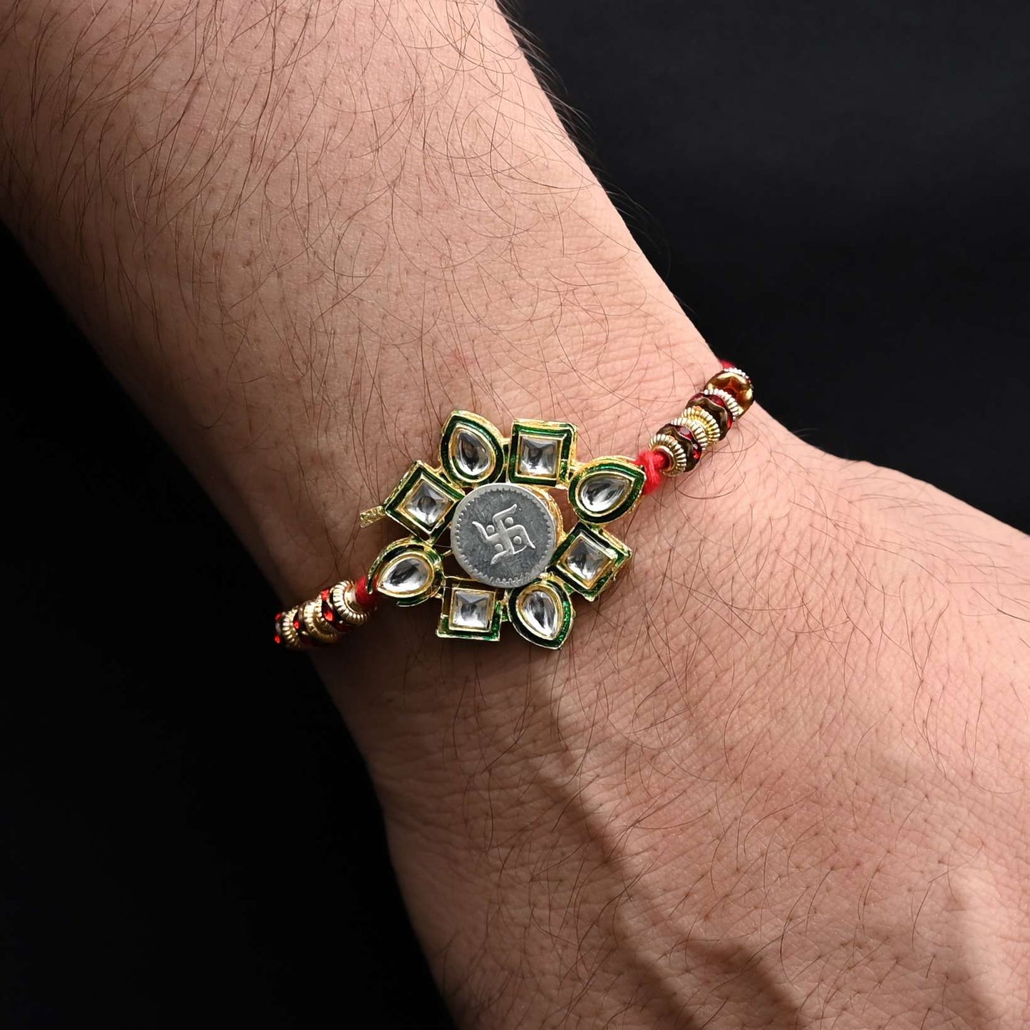 Elegant Rakhi with a silver Swasthik flower and colorful beads, ideal for boys