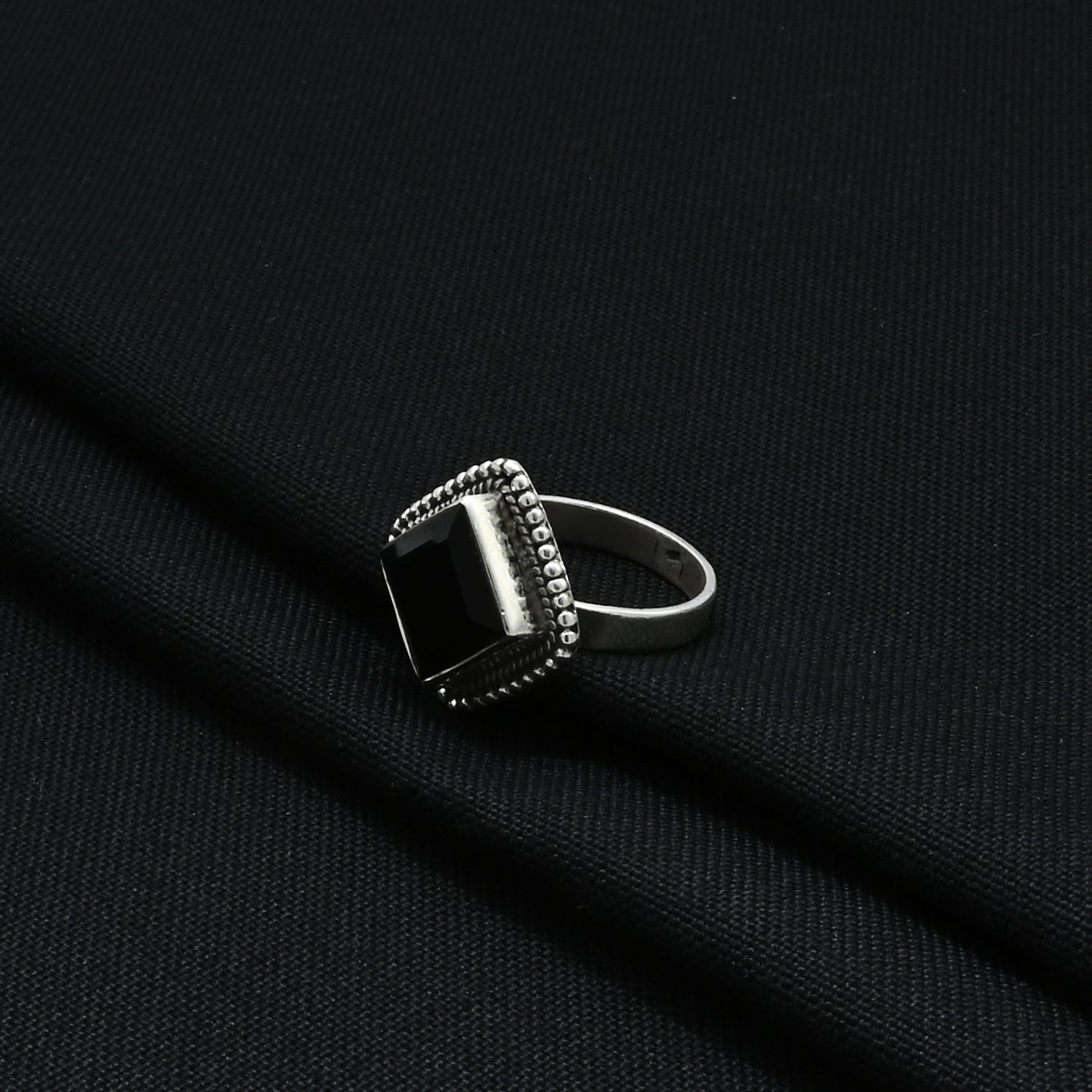 Stylish silver ring with beady black accents, perfect for adding a touch of class and modern elegance