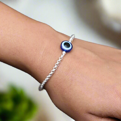 Elegant silver bracelet with a round blue evil eye centerpiece