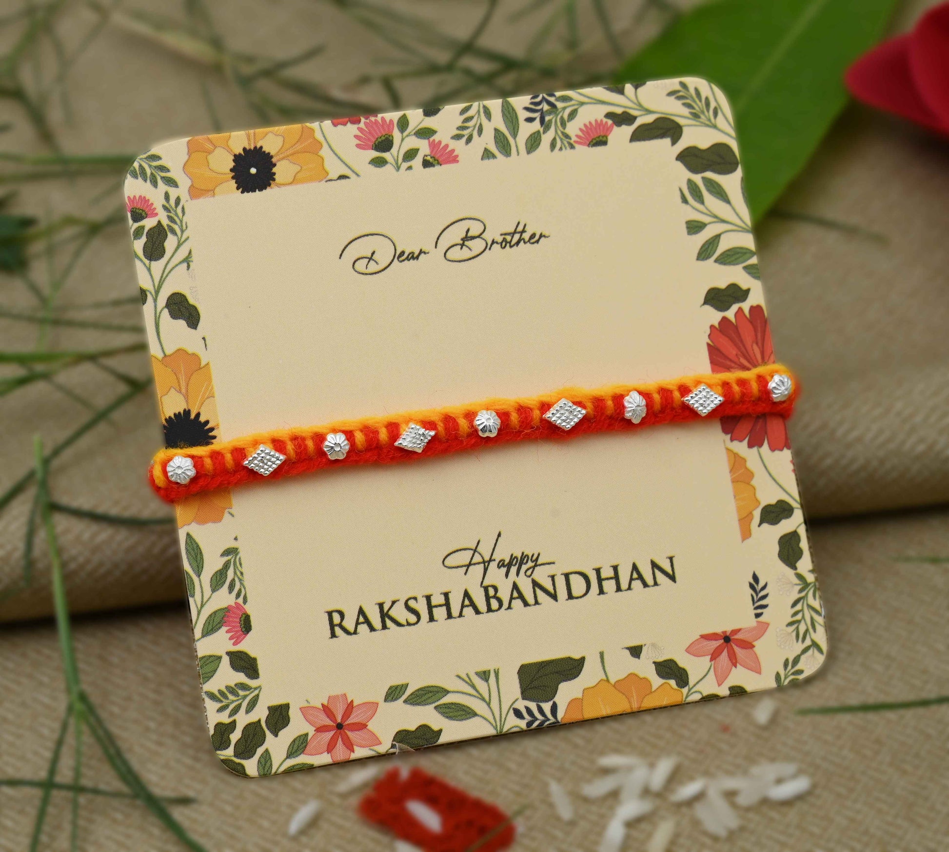 Silver Rakhi with a small flower design, perfect for boys.