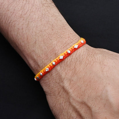 Elegant Rakhi with a silver small flower motif, ideal for boys.