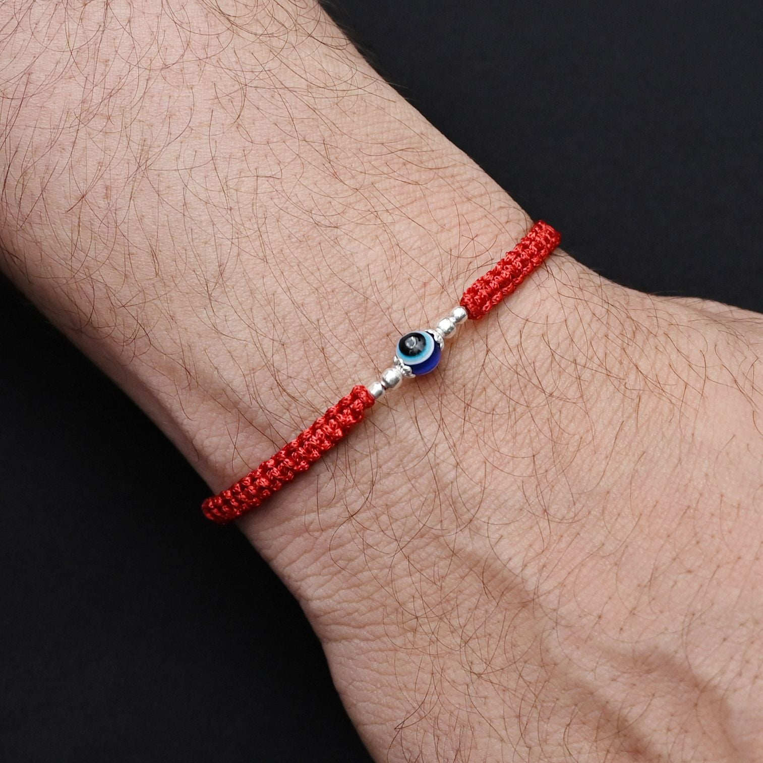 Traditional silver Rakhi with an Evil Eye charm and silver beads for boys.