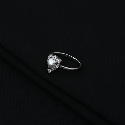 Charming silver ring adorned with pearl heart motif.