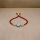 Elegant silver evil eye bracelet on adjustable red thread.