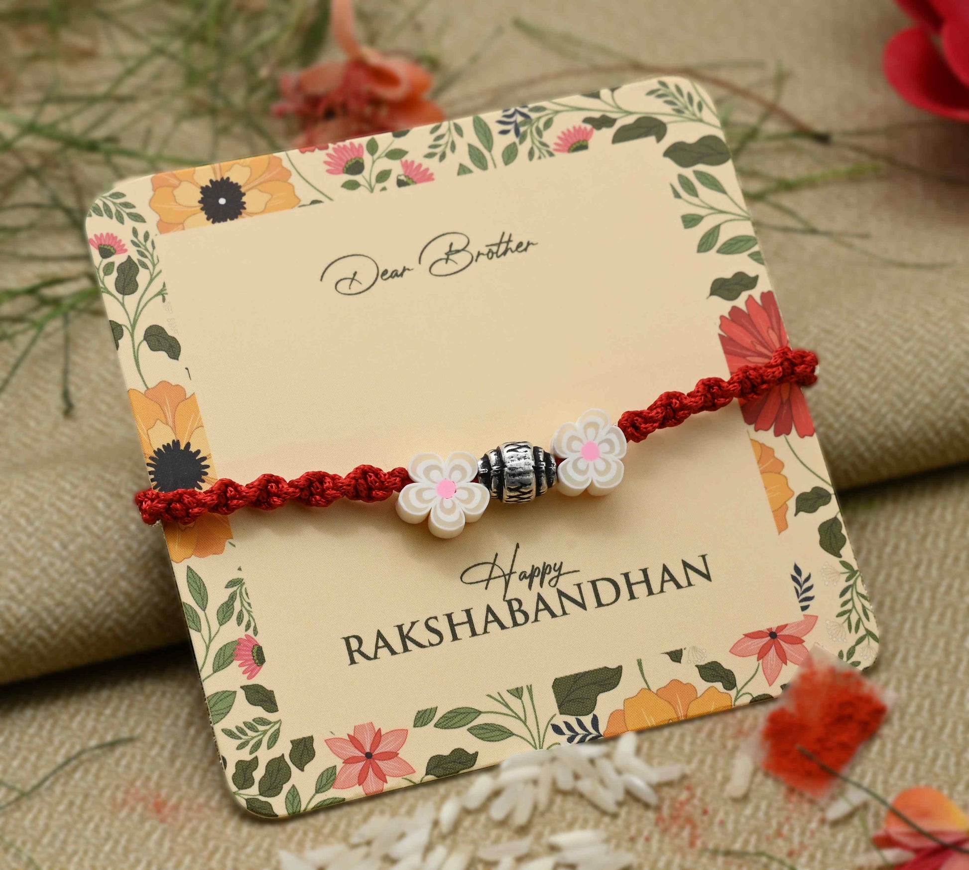 Silver center bead design with two cream-colored flowers, perfect Rakhi for boys.